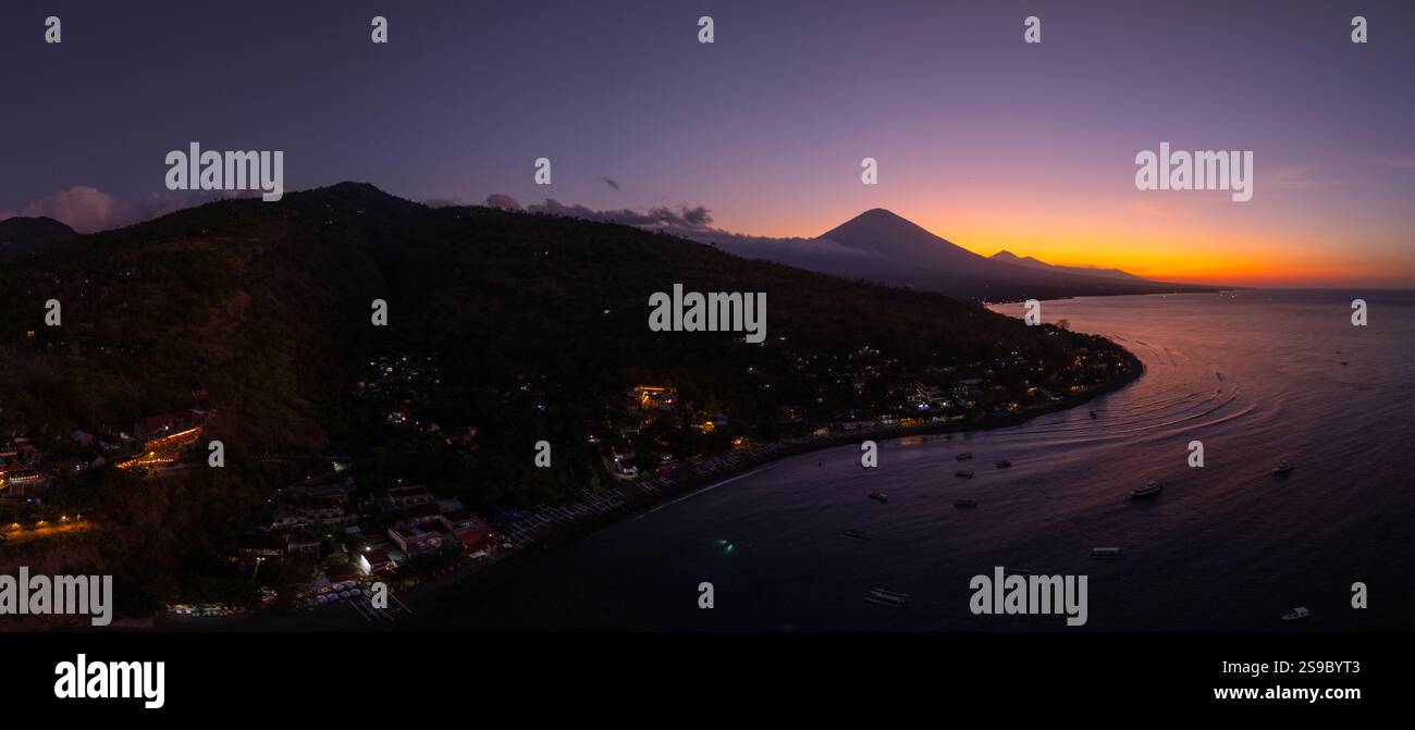 Prise de vue panoramique par drone de la côte avec le mont du volcan et le crépuscule du coucher du soleil avec la mer calme à Bali. Banque D'Images