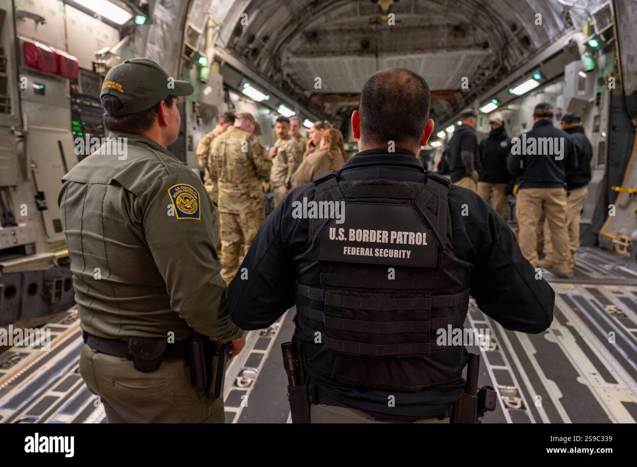 Tucson, États-Unis. 23 janvier 2025. Les agents des douanes et de la protection des frontières des États-Unis se préparent à charger des migrants sans papiers sur un U. S Air Force avion de transport C-17 Globemaster III pour le premier vol de retrait à l'aéroport international de Tucson, le 23 janvier 2025 à Tucson, Arizona. Les vols de renvoi étaient à la direction du président Donald Trump et c’est la première fois que des avions militaires ont été utilisés pour des vols de déportation. Crédit : SRA Devlin Bishop/U. S Air Force/Alamy Live News Banque D'Images