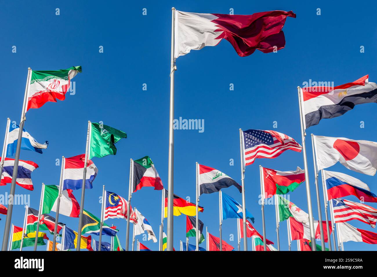 De nombreux pays du monde drapeaux nationaux agitant ensemble sur le vent, drapeau qatari au centre et américain, iranien, japonais, chinois, russe, égyptien, somalien Banque D'Images