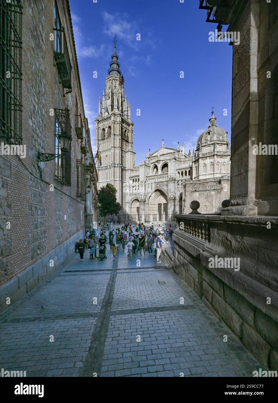 Scène de rue à Tolède Espagne avec la cathédrale de Tolède. Les touristes sont vus assis et parlant Banque D'Images