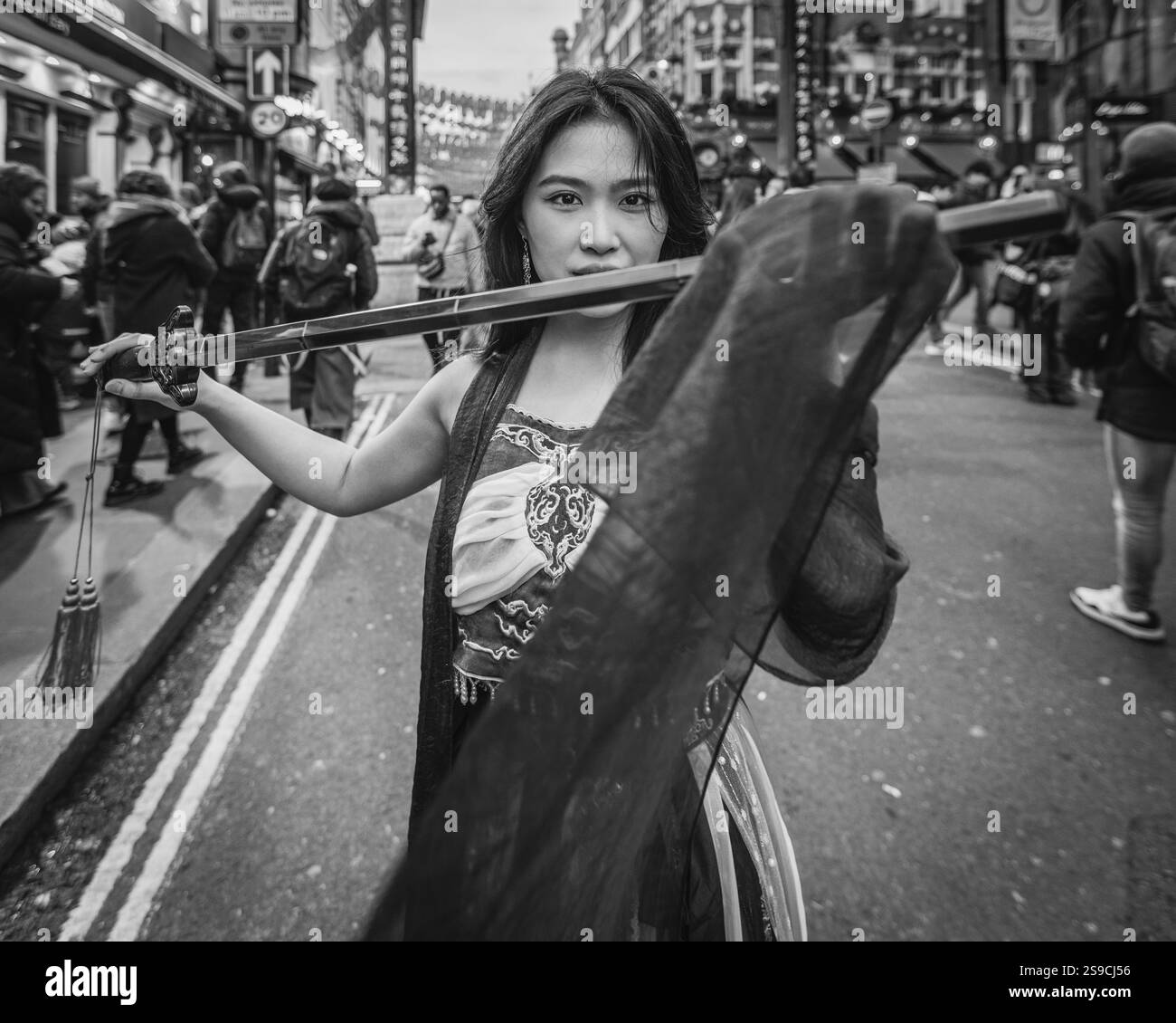 Une fille chinoise tient une épée pour accueillir le nouvel an lunaire du serpent dans Chinatown de Londres. Banque D'Images