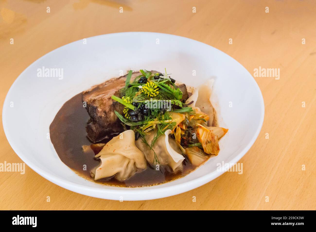 Elégante assiette de bœuf braisé gourmand avec wontons et légumes de saison Banque D'Images