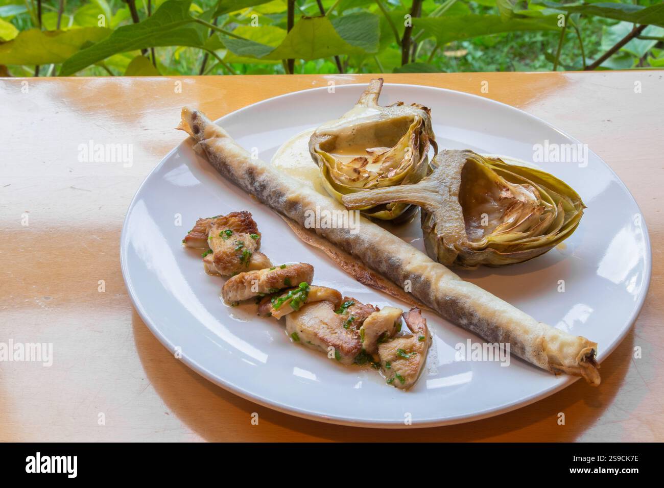 Assiette gastronomique avec artichauts et champignons sur une table Banque D'Images