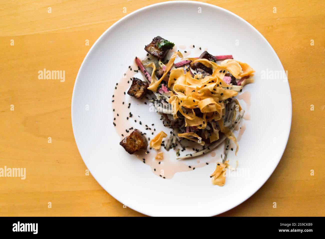 Plat gastronomique avec viande barbecue, légumes et garniture sur assiette blanche Banque D'Images