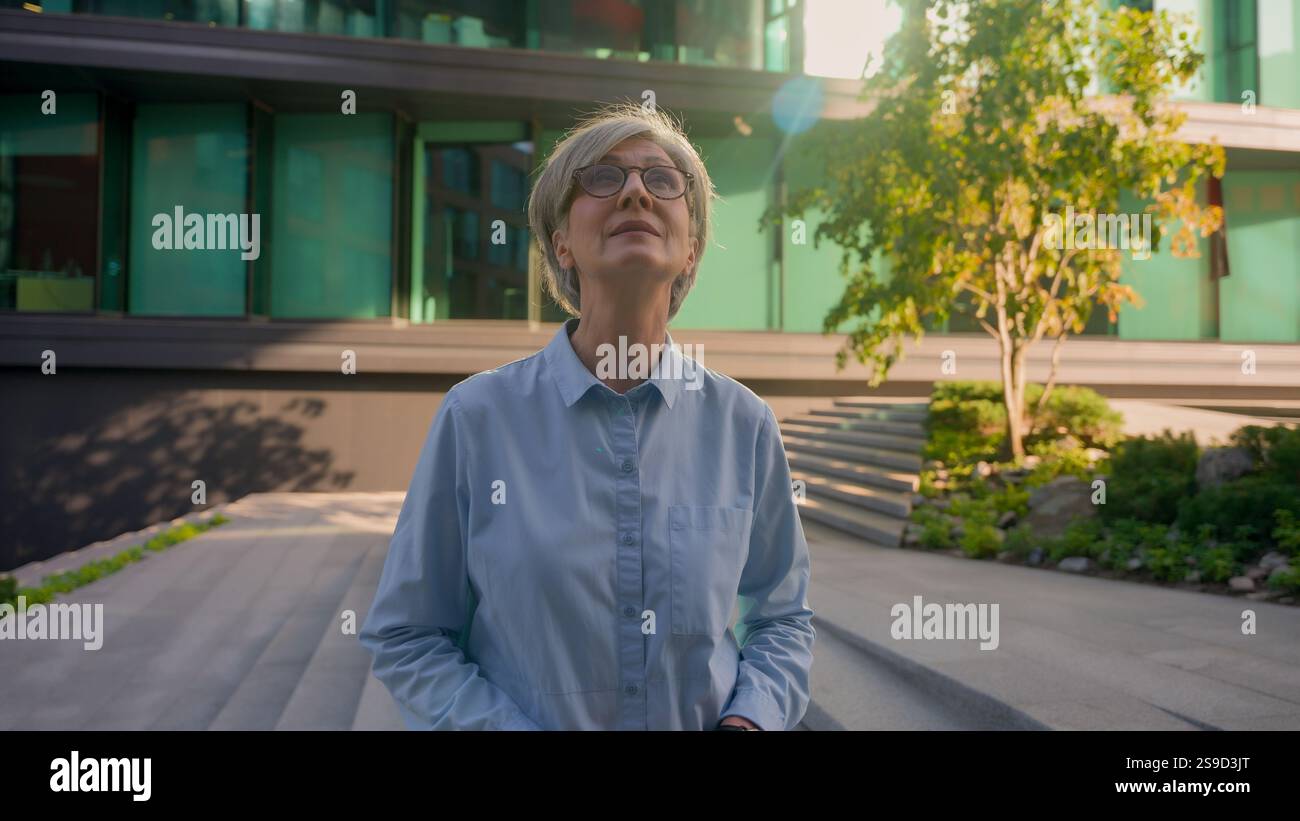 Portrait femme d'affaires Caucasien 50s adulte moyen âge gris-cheveux femme âgée senior vieille femme regardant autour dans le centre-ville aîné inspiré réussi Banque D'Images