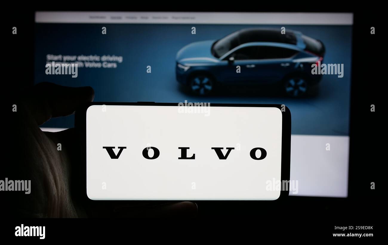 25 octobre 2024, Allemagne : dans cette illustration photo, une personne tient un téléphone portable avec le logo de la société automobile suédoise Volvo car AB sur l'écran devant la page Web de l'entreprise. (Crédit image : © timon Schneider/SOPA images via ZUMA Press Wire) USAGE ÉDITORIAL SEULEMENT ! Non destiné à UN USAGE commercial ! Banque D'Images