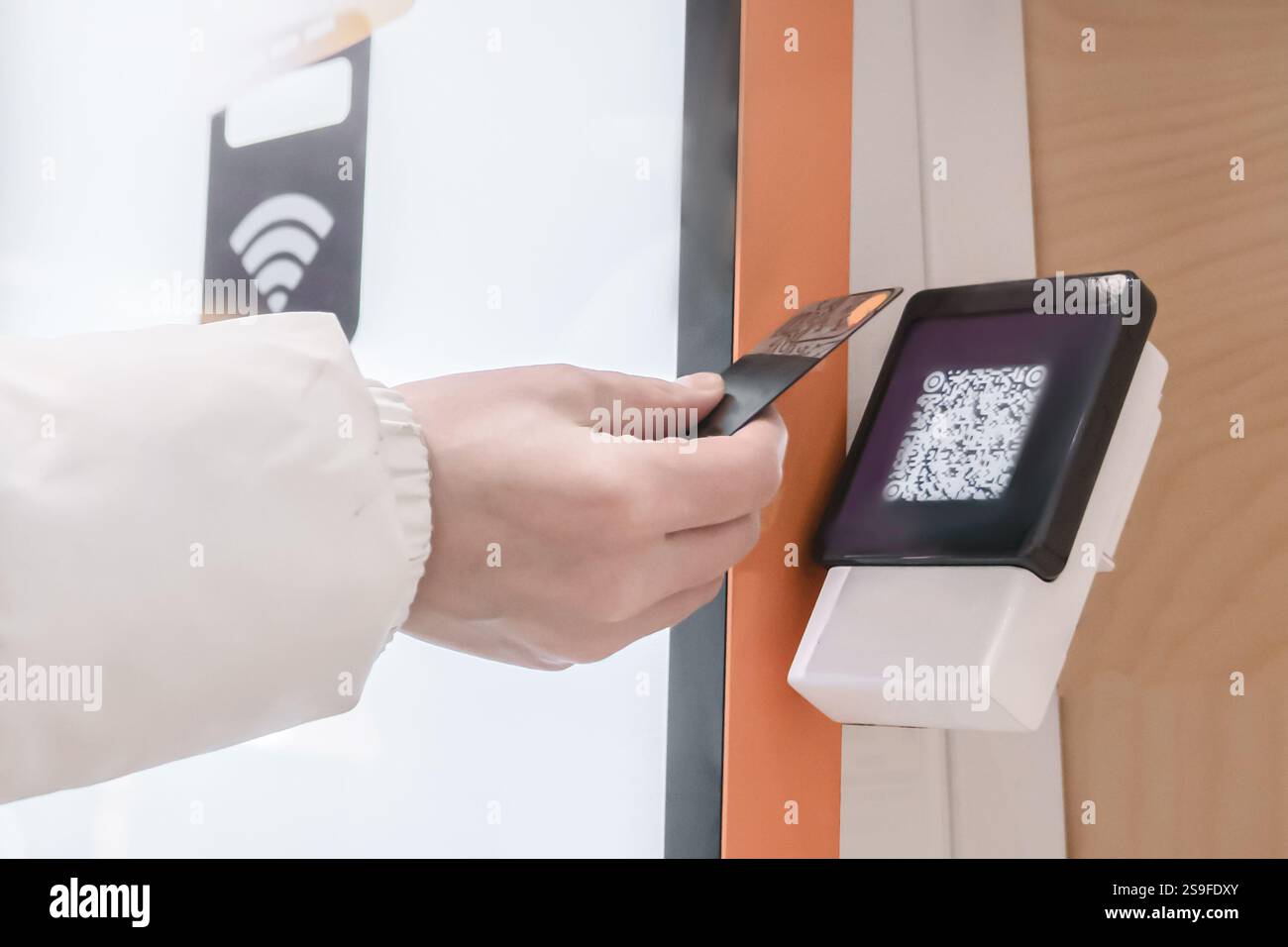 Une main utilise une technologie de paiement sans contact avancée avec un scanner de code QR pour plus de commodité, paiement en ligne via code QR par le biais de la Termin Banque D'Images