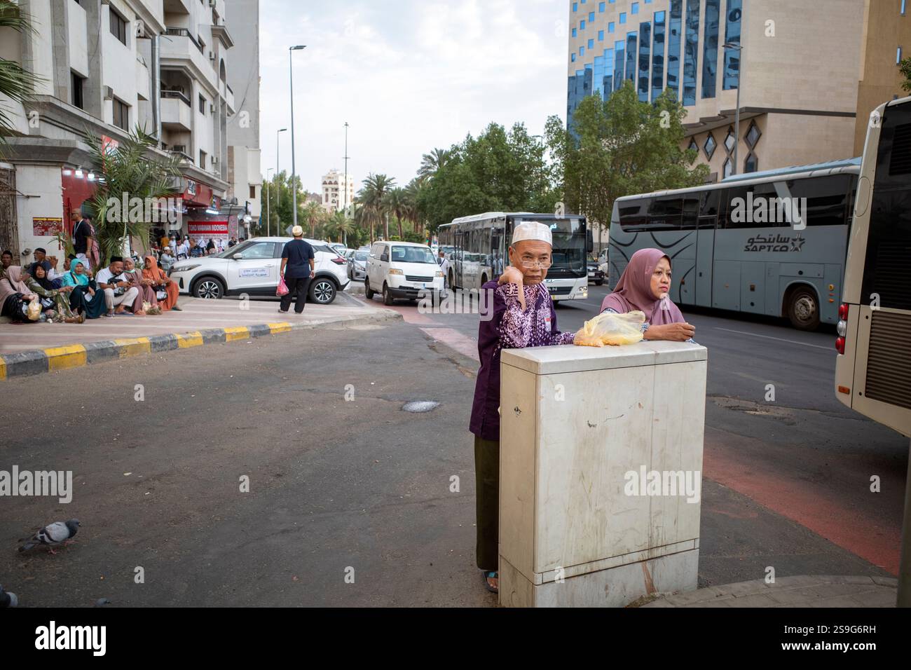 La Mecque, Arabie Saoudite - 12 juin 2024 : un couple de pèlerins indonésiens du Hajj et de l'Oumrah attendent le bus à Makkah, Arabie Saoudite. Hajj 2024. Banque D'Images