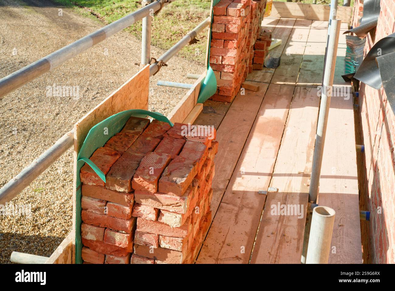 Construire ceux qui possèdent leur maison. Travaux de construction de maisons. Construction d'un bâtiment en bois avec revêtement en brique. Banque D'Images