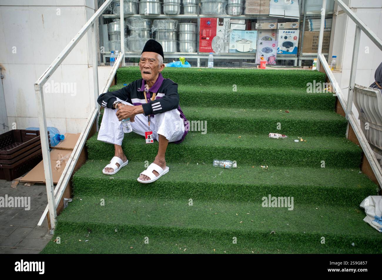 La Mecque, Arabie Saoudite - 13 juin 2024 : un vieil homme, pèlerins du Hajj et de l'Umrah d'Indonésie assis devant un hôtel à Makkah, Arabie Saoudite. Hajj 2024. Banque D'Images