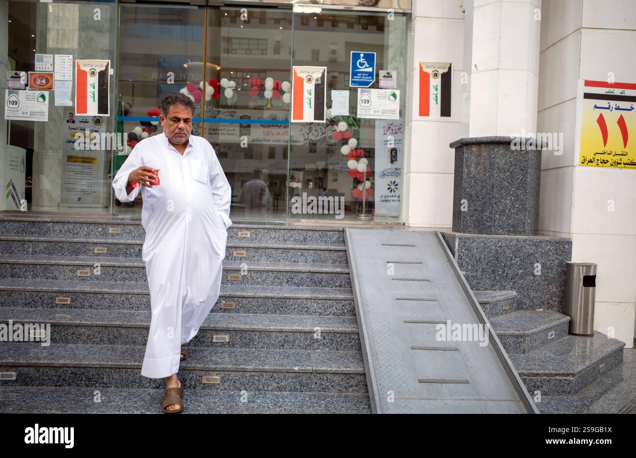 La Mecque, Arabie Saoudite - 13 juin 2024 : pèlerins du Hadj et de l'Oumrah d'Irak marchant devant un hôtel à Makkah, Arabie Saoudite. Hajj 2024. Banque D'Images