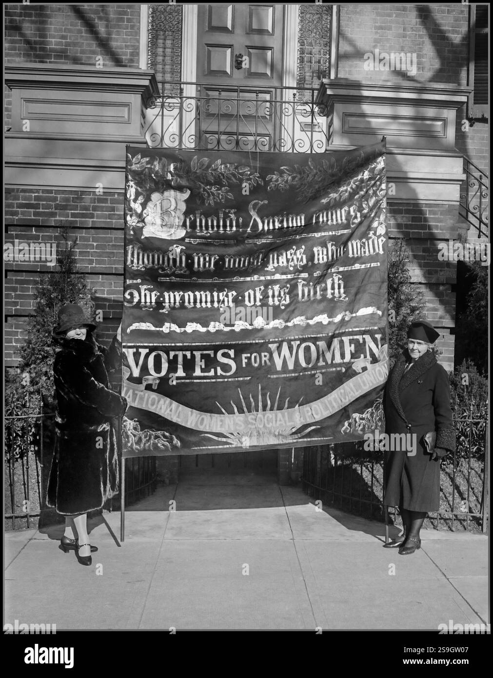CHRISTABEL PANKHURST le drapeau militant suffragette porté par Emmaline Pankhurst lors d'une manifestation d'avant-guerre à Londres arrive à Washington. À Washington, pour assister aux services commémoratifs à sa mère Emmaline Pankhurst, célèbre leader du suffrage anglais, Miss Christabel Pankhurst apporta avec elle le célèbre drapeau militant porté par sa mère lors de la manifestation d'avant-guerre à Londres. À gauche se trouve Miss Pankhurst et à droite MRS William Kent, de Californie, qui présidera les services qui auront lieu au Capitole des États-Unis le 8 décembre date 1929 Banque D'Images