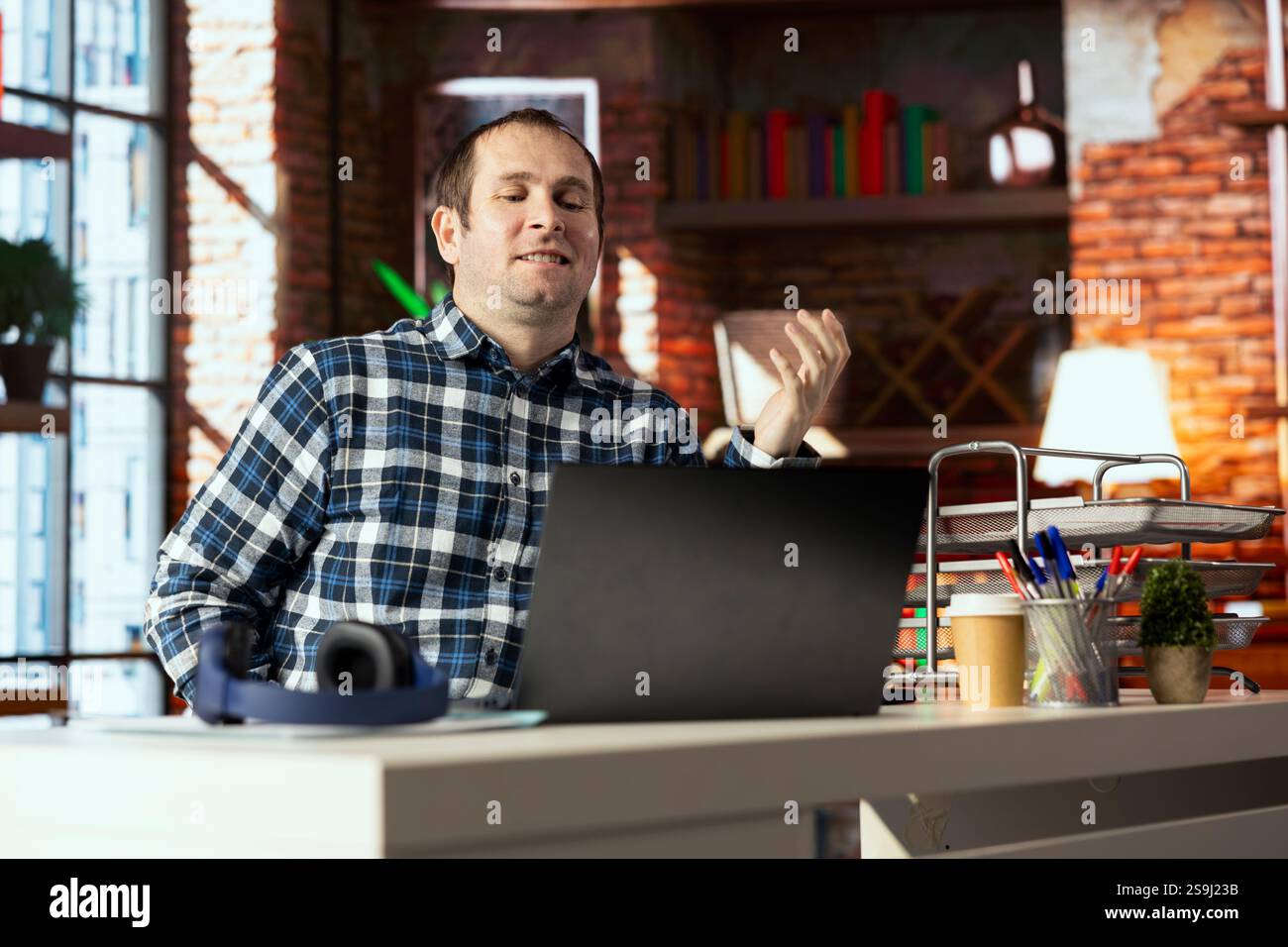 Travailleur souriant au bureau à domicile se sentant fier après avoir vu qu'il a atteint l'objectif de vente sur l'écran de l'ordinateur portable. Smug employé se réjouissant après avoir reçu une promotion au travail, lisant l'e-mail sur ordinateur portable Banque D'Images