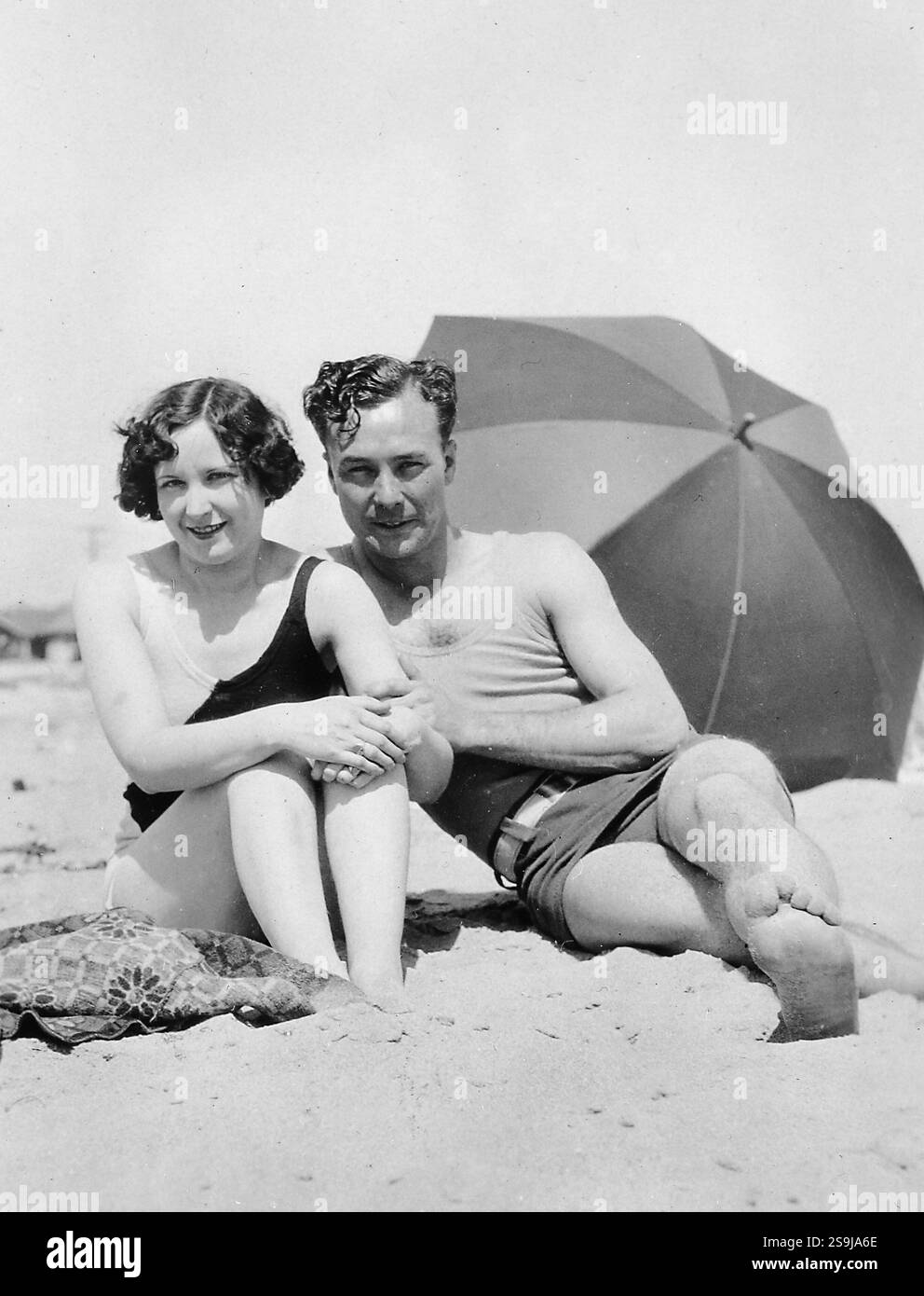 Couple élégant pose sur une plage de sable, vers 1925. Banque D'Images