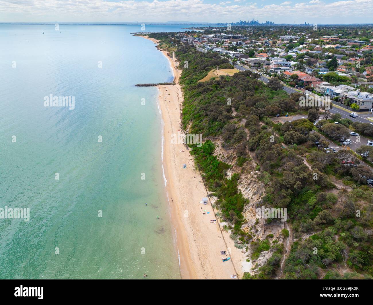 Vue aérienne d'une étroite plage de sable sous des falaises végétalisées et d'une ville côtière à Sandringham à Melbourne, Victoria, Australie Banque D'Images