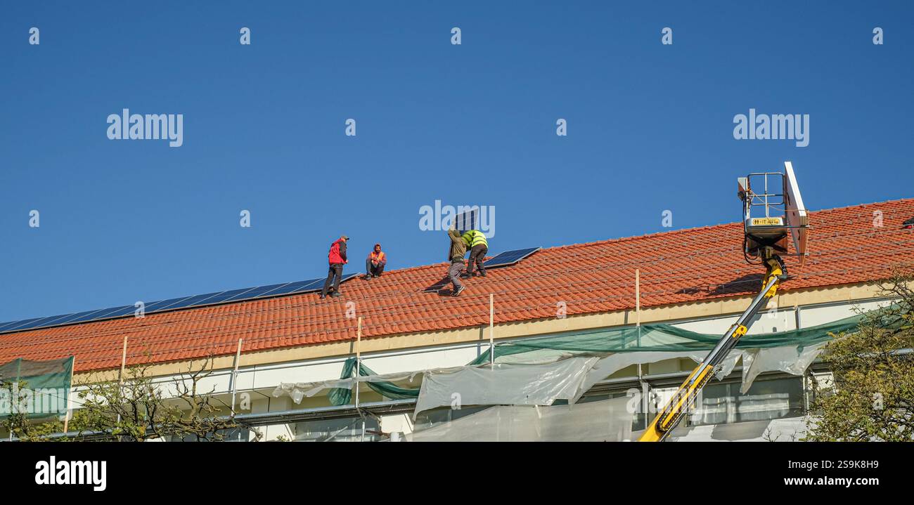 Sibiu, Roumanie - 12 novembre 2024. les ouvriers installent des panneaux photovoltaïques sur le toit Banque D'Images