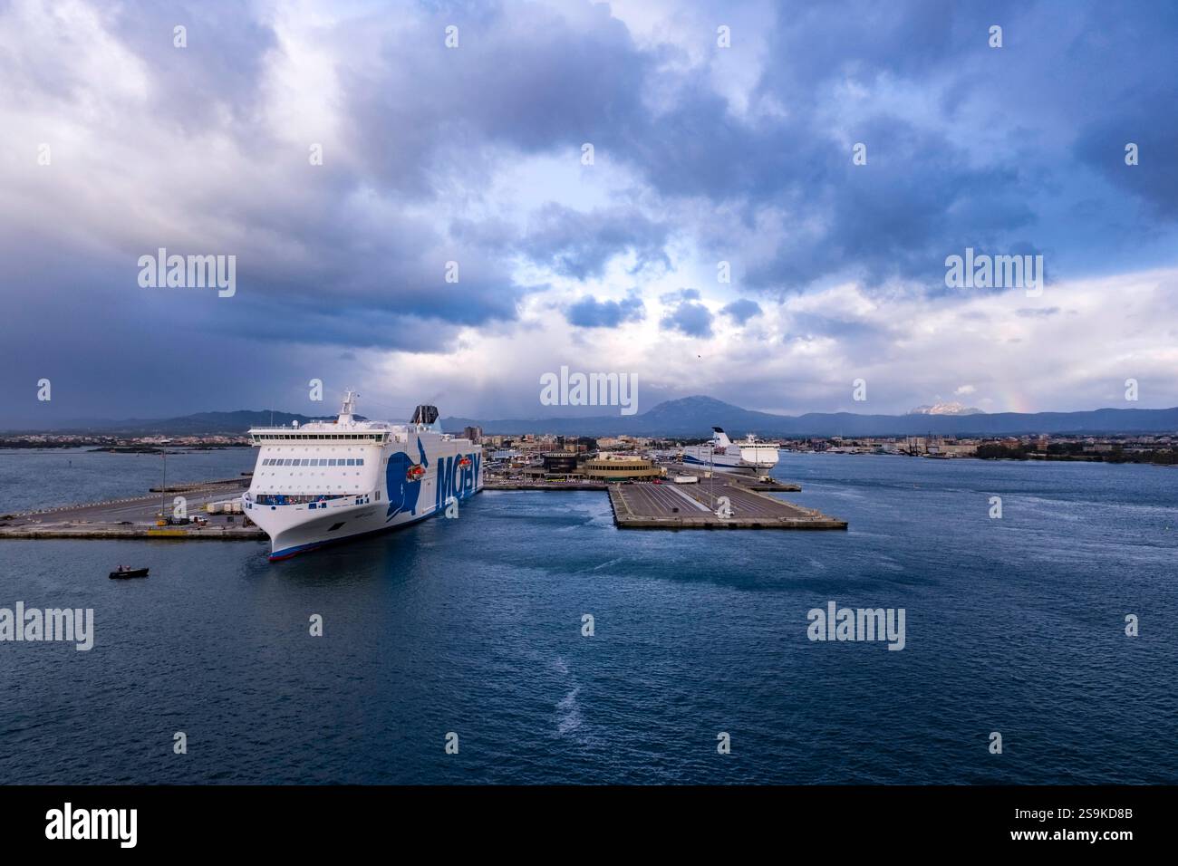 Le ferry Moby Legacy de Moby Lines à l'ancre dans le port d'Olbia, maisons de la ville au loin. Olbia Sardaigne Italie FB_2024_1221 Banque D'Images