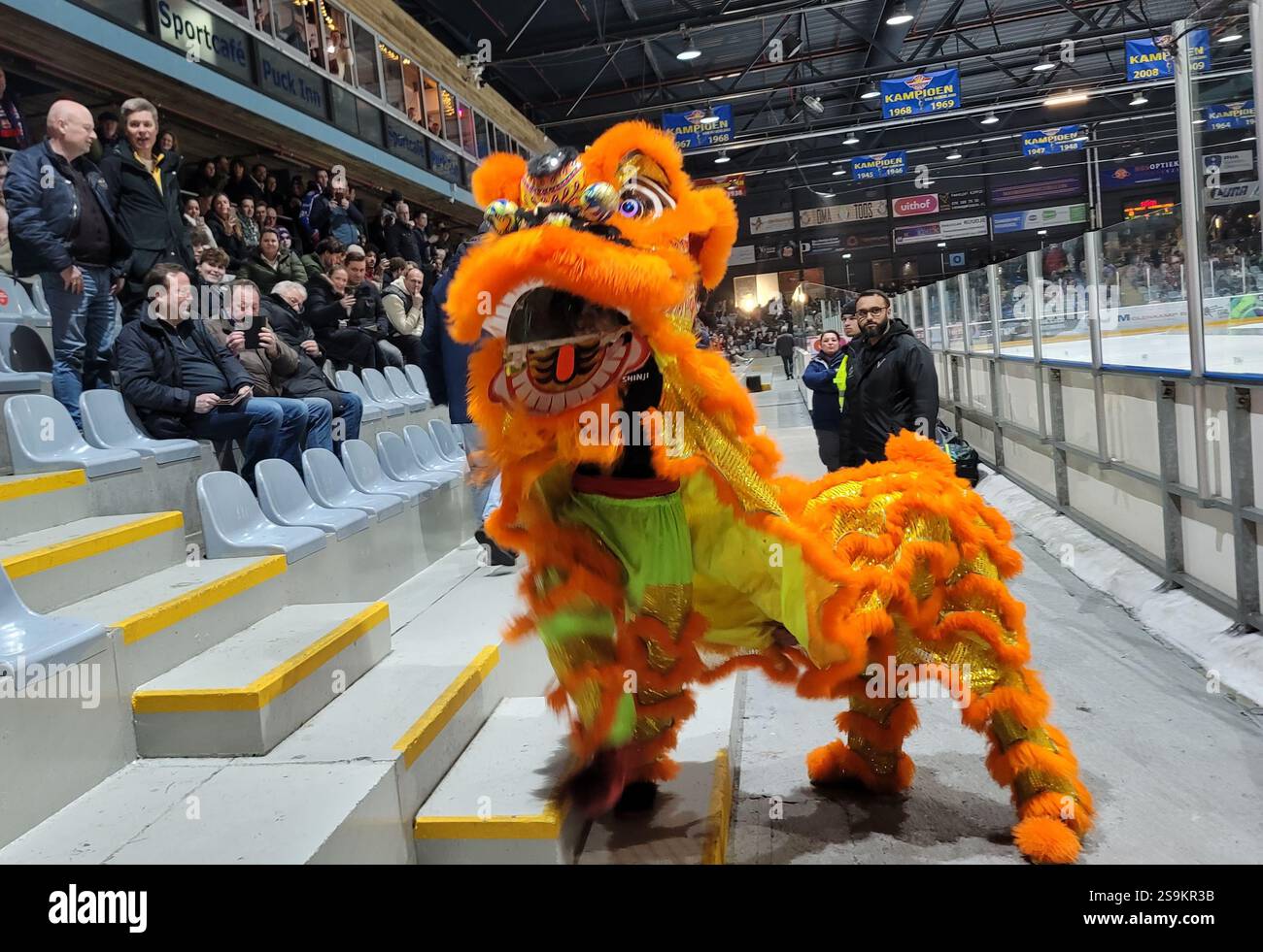 La Haye, pays-Bas. 24 janvier 2025. Les danseurs du lion se produisent à la patinoire de hockey sur glace du de Uithof Sports Center à la Haye, aux pays-Bas, le 24 janvier 2025. Le choc retentissant des gongs et des tambours a fait écho à l'arène de hockey sur glace de la Haye vendredi soir alors qu'une danse du lion animée a captivé les spectateurs néerlandais lors de la célébration du « Happy Spring Festival ». ALLER AVEC 'la danse du lion déclenche des échanges culturels dans l'arène de hockey sur glace néerlandaise' crédit : Wang Xiangjiang/Xinhua/Alamy Live News Banque D'Images