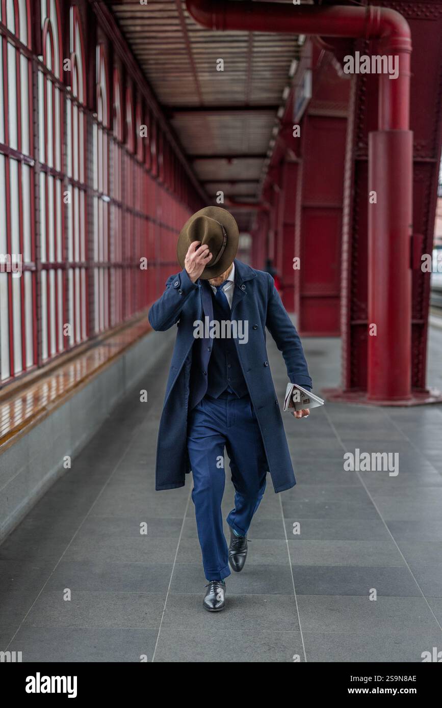 Gentleman marchant avec chapeau et journal dans un style vintage Banque D'Images