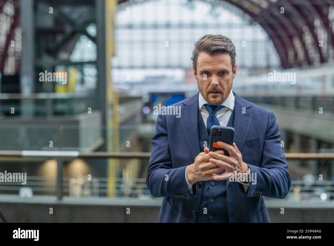 Homme d'affaires utilisant le téléphone à la gare Banque D'Images