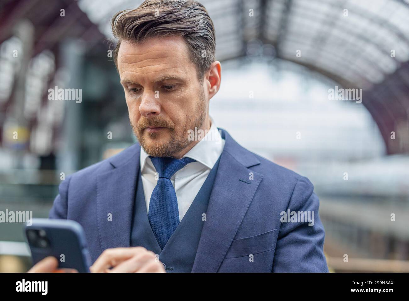 cadre ciblé utilisant un smartphone à la gare Banque D'Images