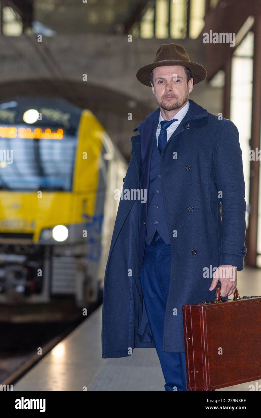 Voyageur avec mallette attendant à la gare pour le train Banque D'Images