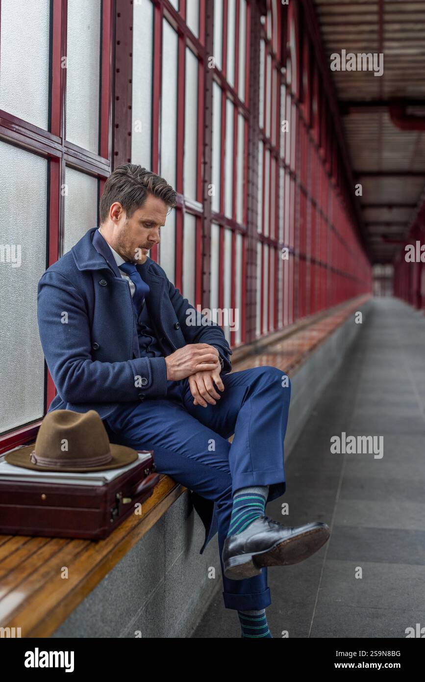 Entrepreneur vérifiant l'heure sur sa montre, en attendant Banque D'Images