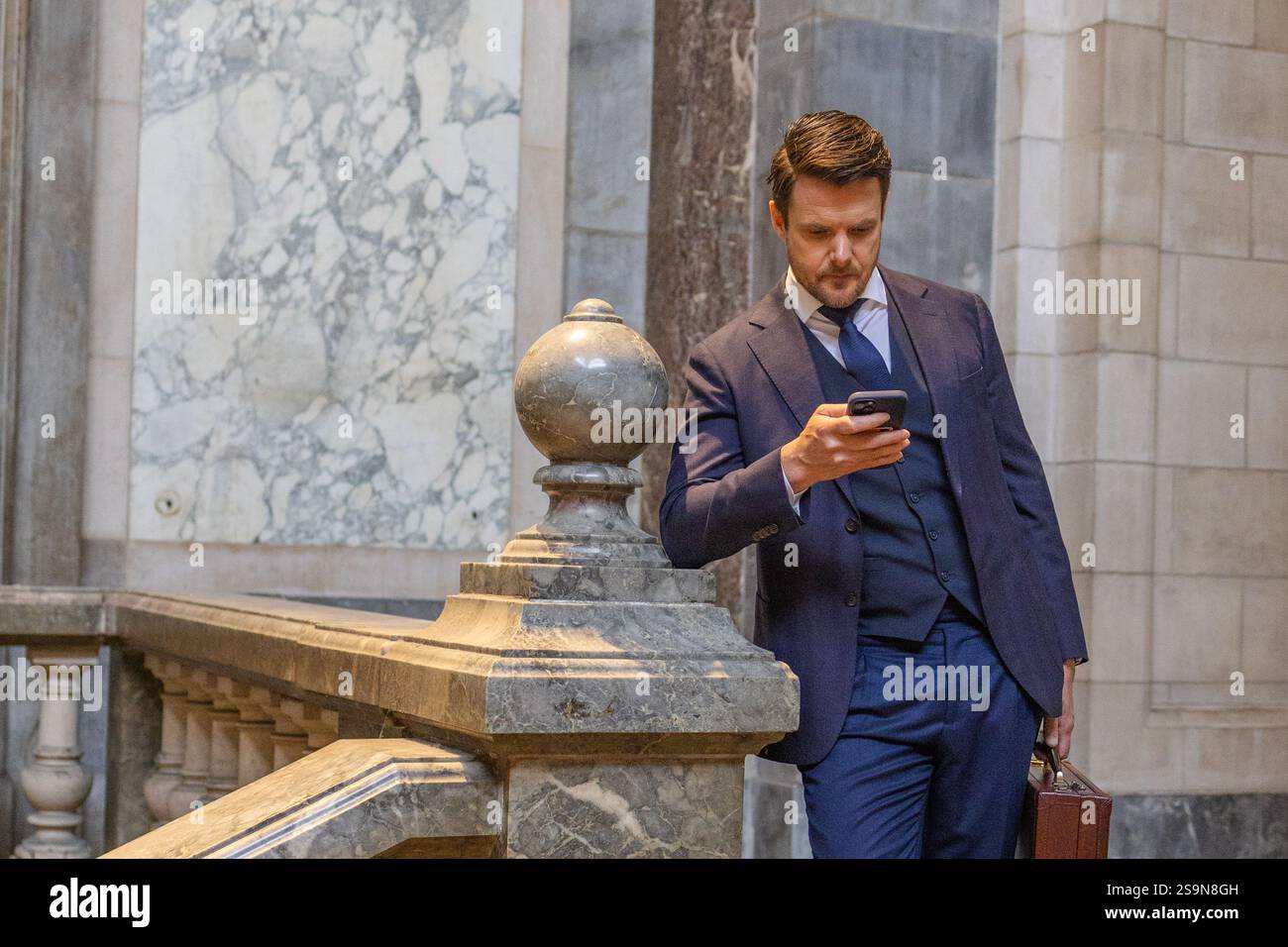 homme d'affaires avec téléphone et mallette vérifiant ses messages Banque D'Images