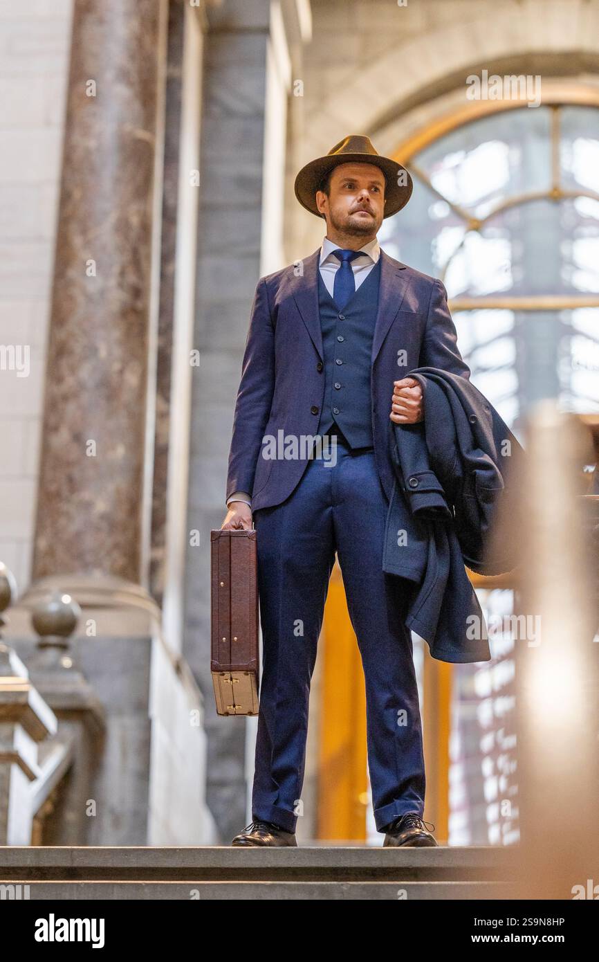 Gentleman en costume Vintage debout avec porte-documents sur les escaliers en marbre Banque D'Images