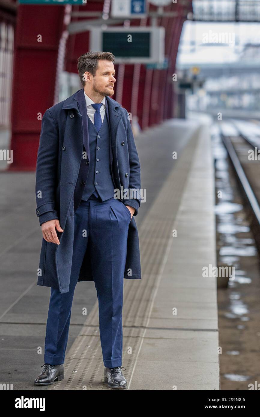 Gentleman attendant calmement sur la plate-forme dans un costume sophistiqué Banque D'Images