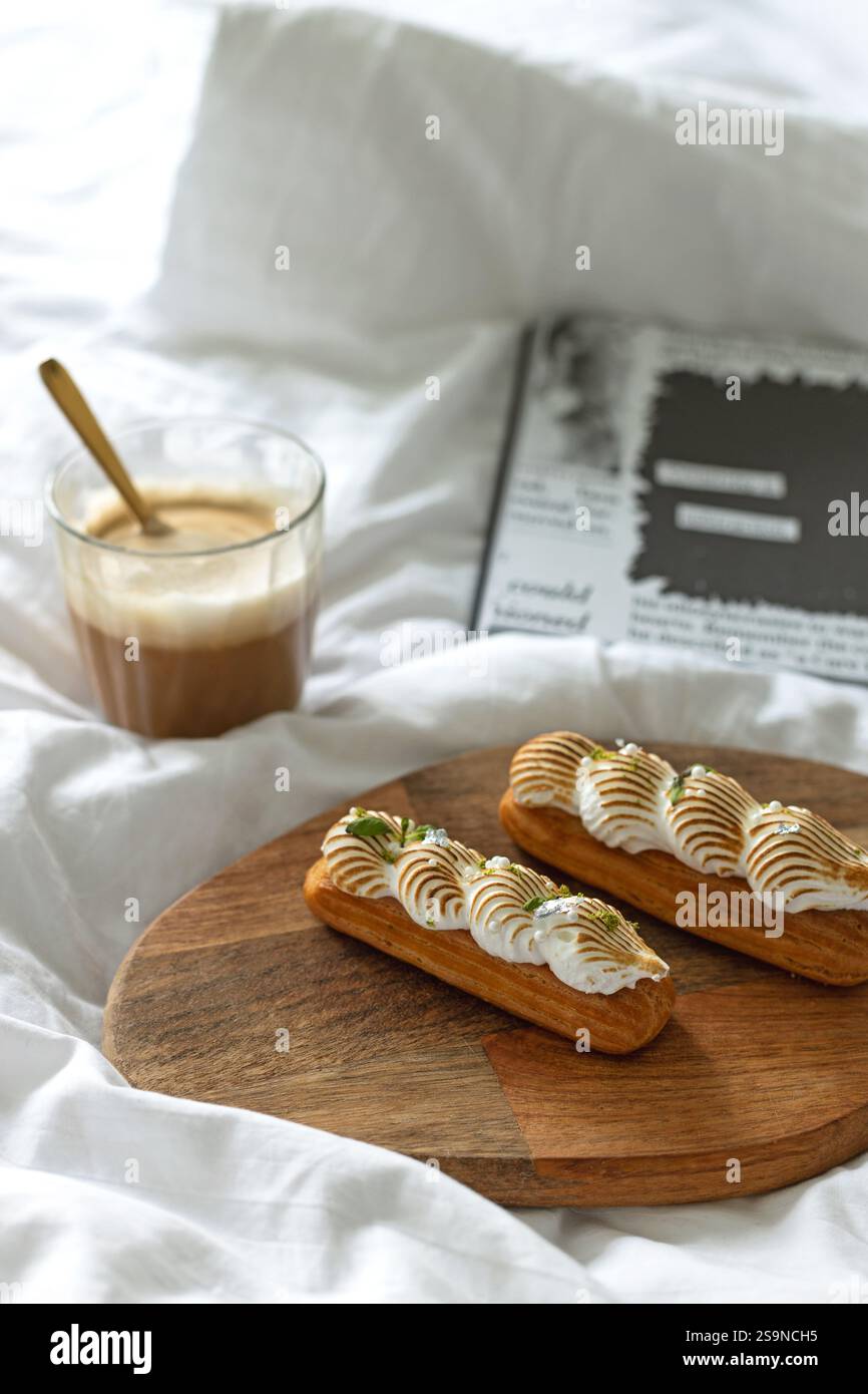 Eclairs avec meringue citron lime et tasse à café au lit Banque D'Images