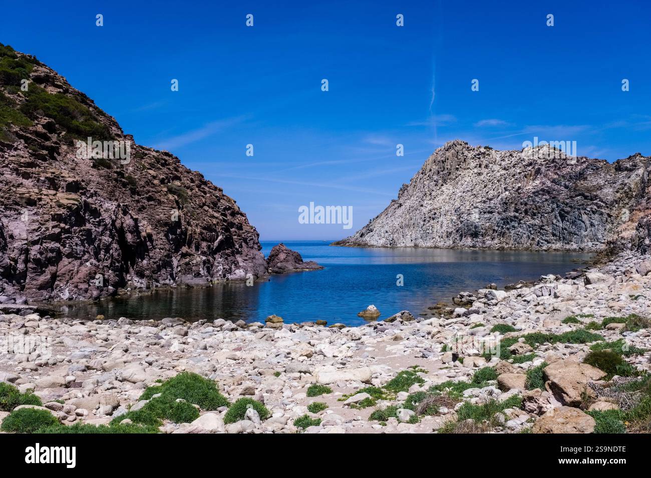 Cala Fico, une petite baie cachée avec une plage rocheuse sur la côte nord-ouest de l'île d'Isola di San Pietro. Banque D'Images