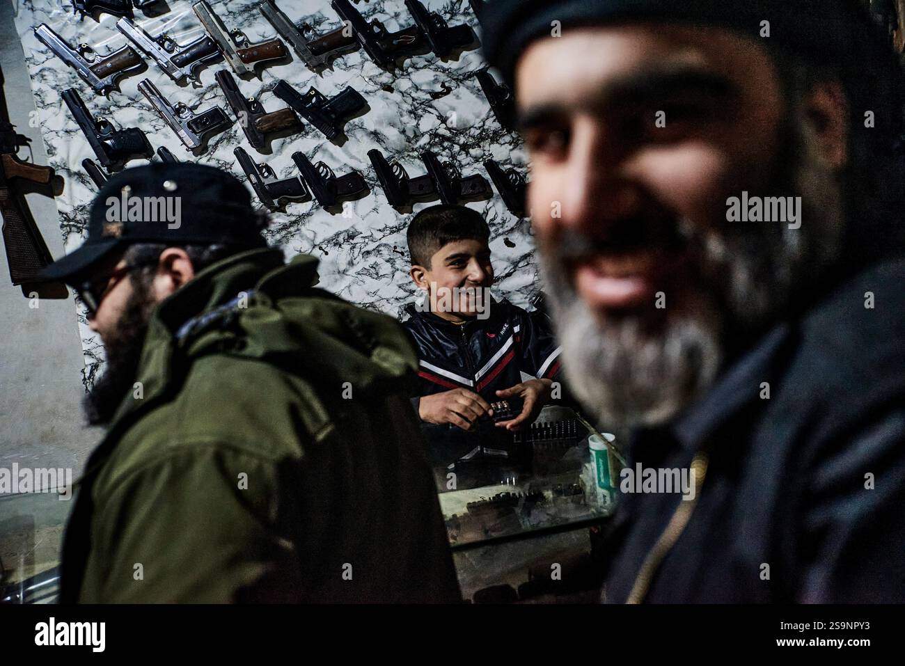 Idleb, Syrie. 21 décembre 2024. Antonin Burat/le Pictorium - chute de Bachar al-Assad : en Syrie, le dictateur est parti - 21/12/2024 - Syrie/Idleb - Idlib, 21 décembre 2024 - Hussein, 10 ans, aide son père dans son magasin d'armes. Depuis qu’Idlib a été coupée du reste du pays dans les premières années de la guerre civile, les armes ont circulé librement là-bas, et n’importe qui peut facilement acheter n’importe quel type de fusil d’assaut, lance-roquettes ou munitions. Crédit : LE PICTORIUM/Alamy Live News Banque D'Images