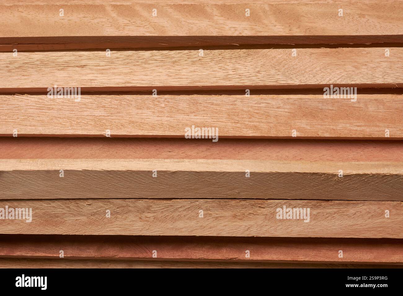 gros plan de planches de bois brun rougeâtre fraîchement coupées ou poncées avec des grains empilés horizontalement, fond abstrait Banque D'Images