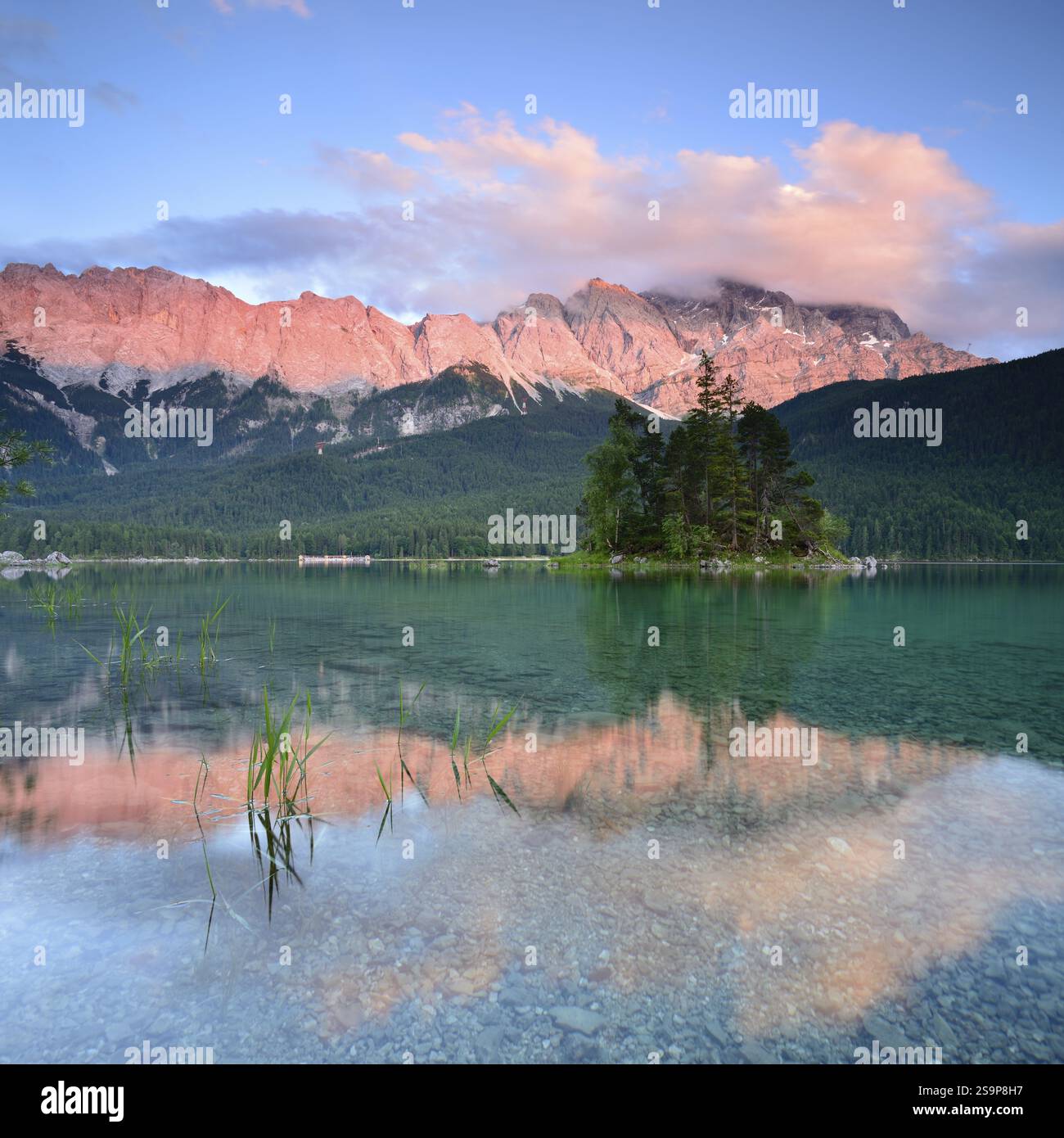 Ambiance du soir et alpenglow au lac Eibsee, en arrière-plan les montagnes Wetterstein avec la Zugspitze, les nuages se déplacent sur les sommets, grain Banque D'Images