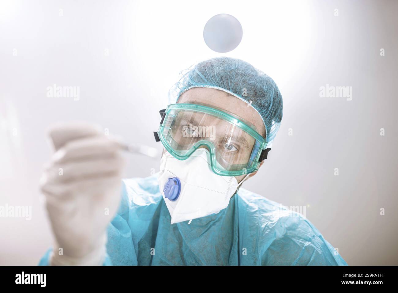 Un professionnel de la santé se concentrant sur une tâche avec un outil à la main Banque D'Images