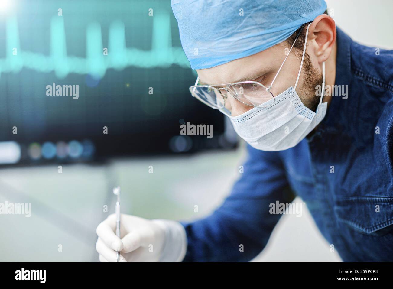 Chirurgien engagé dans une tâche, avec concentration et précision, portant un équipement de protection standard Banque D'Images