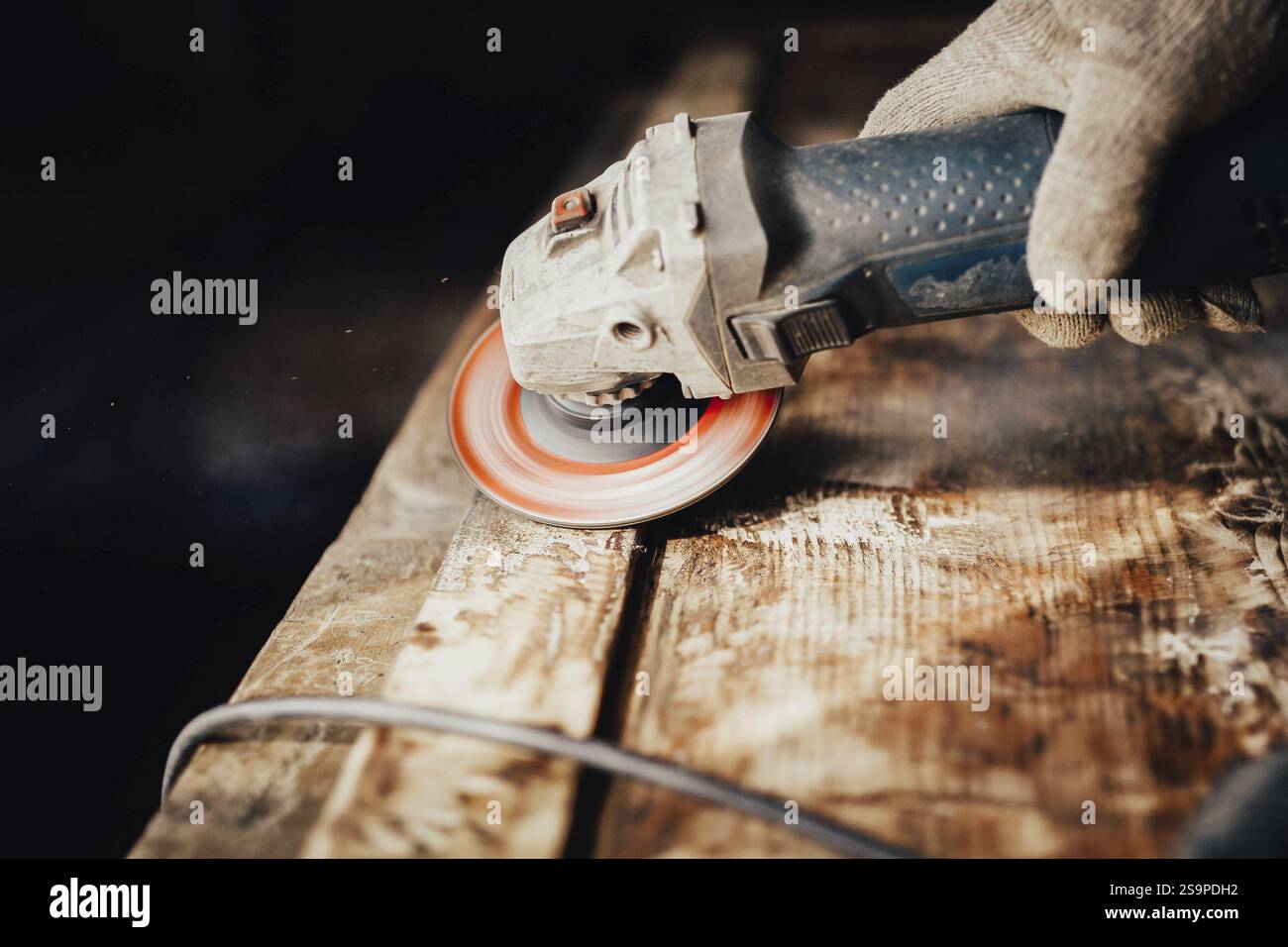 Outil électrique en mouvement ponçant une planche de bois, illustrant une tâche pratique de bricolage Banque D'Images