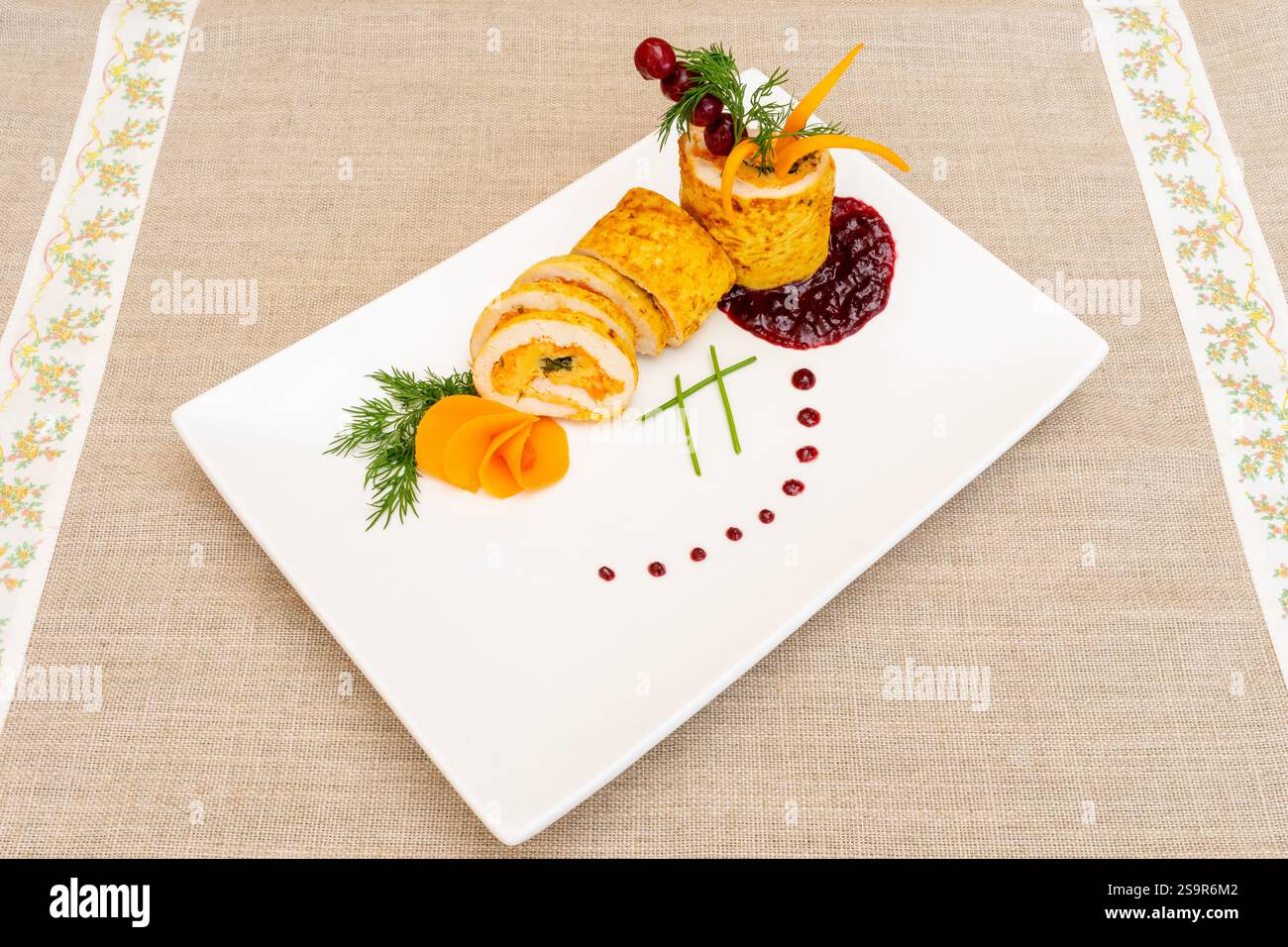 Un plat gastronomique magnifiquement agencé présente des crêpes roulées fourrées de poulet et de légumes frais. Garni d'herbes, de sauces et de veget coloré Banque D'Images