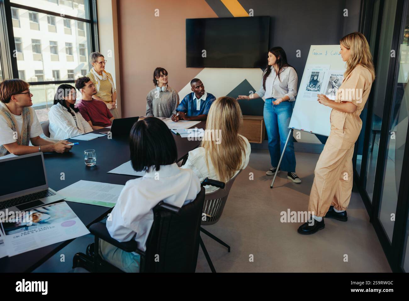Groupe diversifié d'étudiants collégiaux dans un environnement de classe de ville, collaborant et discutant des idées lors d'une présentation créative en classe. Inclut t Banque D'Images