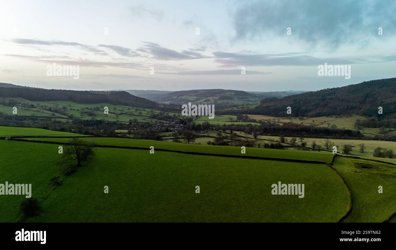 Vue imprenable sur la paisible campagne anglaise avec des collines, des champs verdoyants et un petit village dans la vallée Banque D'Images