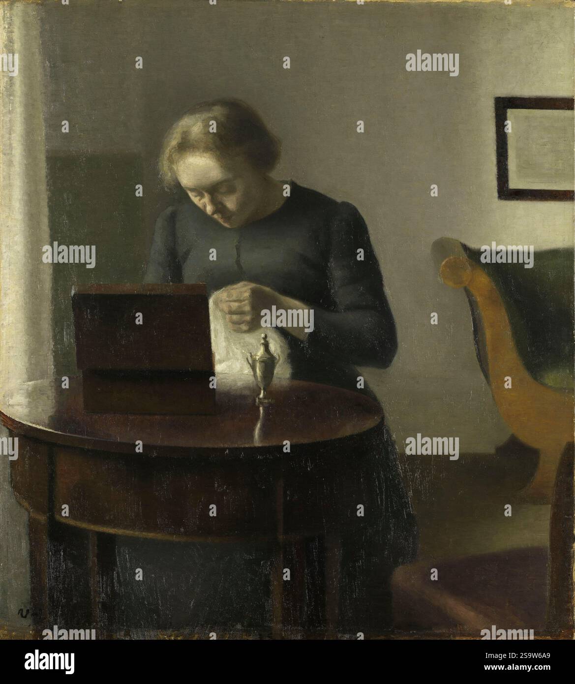 La femme de l'artiste à une table à coudre. Vilhelm Hammershøi. Probablement 1897. Banque D'Images