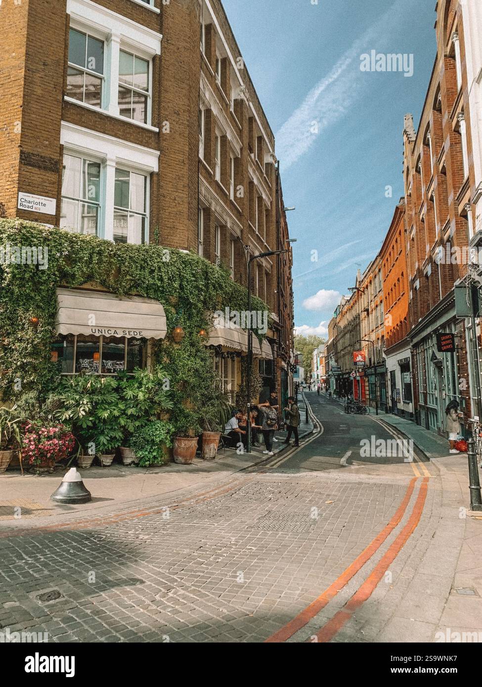 Une scène de rue dynamique près de Shoreditch, Londres, mettant en valeur le mélange éclectique de la vie urbaine et de l'architecture contemporaine. Banque D'Images