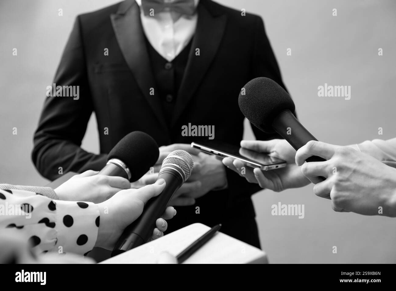 Journalistes interrogeant des célébrités, gros plan. Tonifié en noir et blanc Banque D'Images