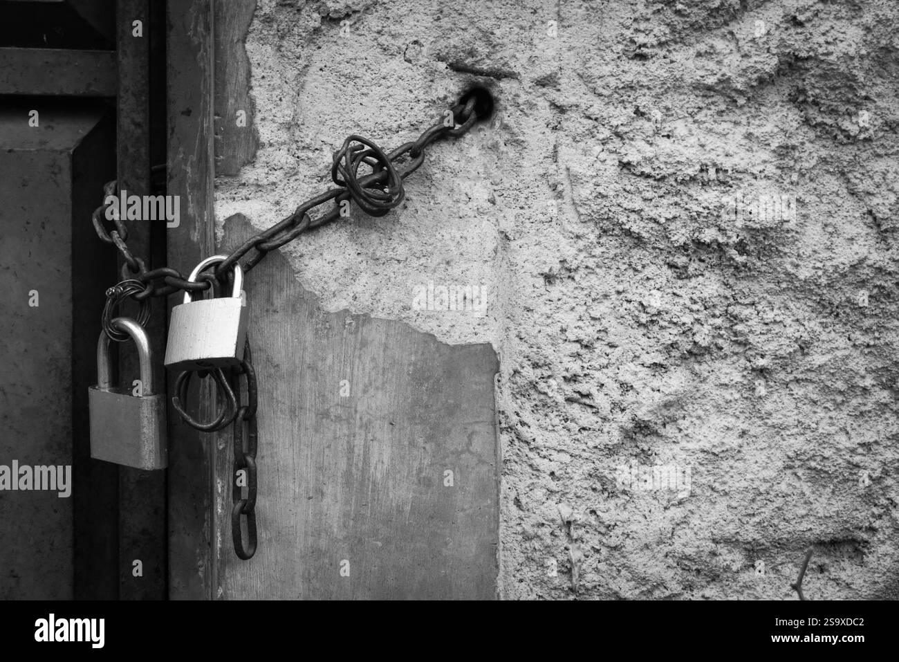 Porte photo noire et blanche verrouillée par chaîne métallique et cadenas Banque D'Images Porte photo noire et blanche verrouillée par chaîne métallique et cadenas Banque D'Images