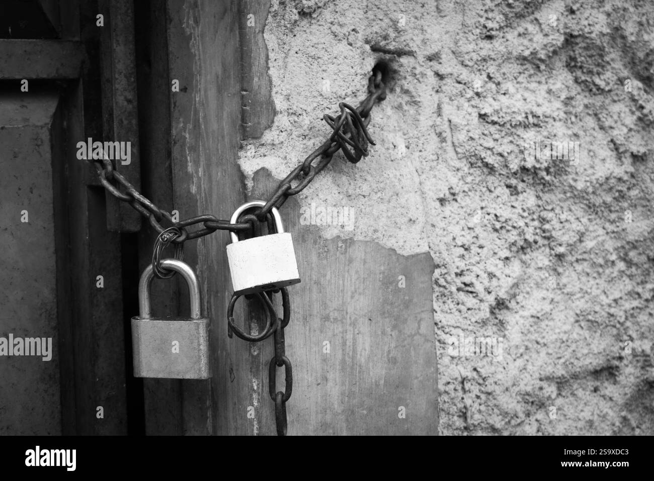 Porte photo noire et blanche verrouillée par chaîne métallique et cadenas Banque D'Images Porte photo noire et blanche verrouillée par chaîne métallique et cadenas Banque D'Images