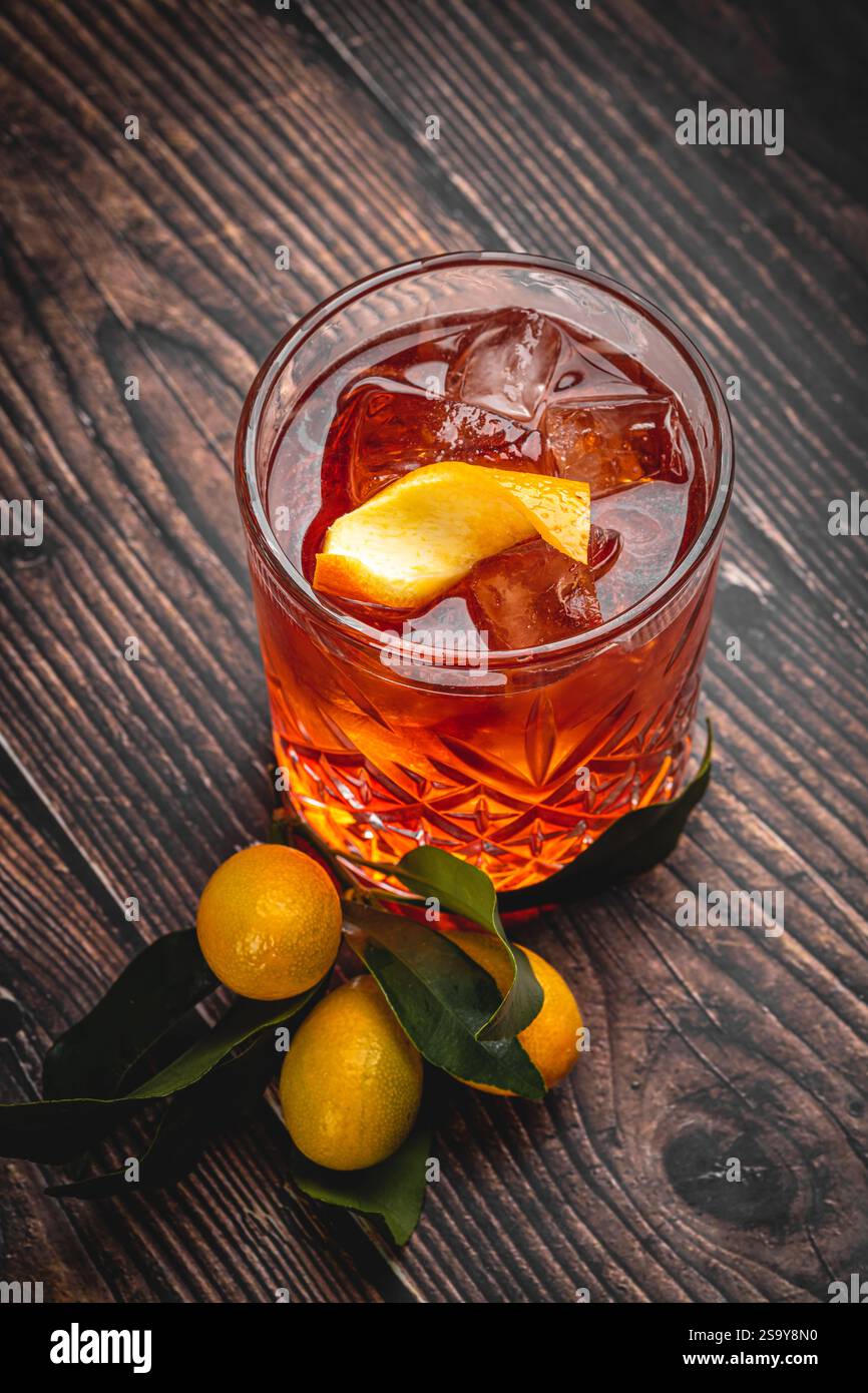 Cocktail kumquat de luxe en verre de cristal sur table en bois Banque D'Images