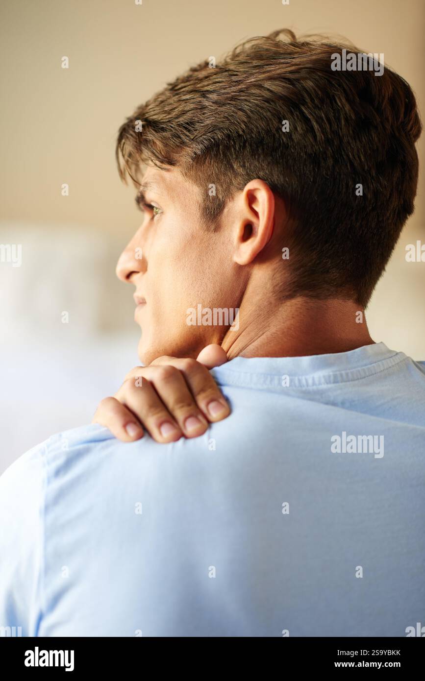 Homme, douleurs à l'épaule et stress dans la chambre, à la maison et dans le dos avec massage pour le soulagement, muscle ou tension. Personne, blessure et inconfort articulaire le matin avec Banque D'Images