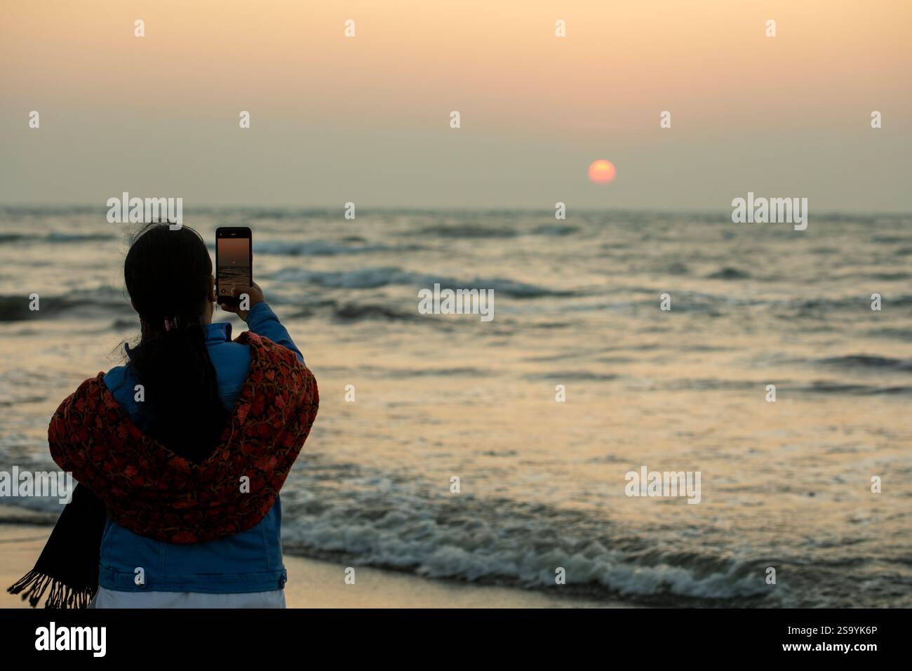 Un touriste profitant de la vue du coucher du soleil depuis la plage de Saint Martin's Island, la seule île corallienne au Bangladesh, située dans la baie du Bengale en C Banque D'Images