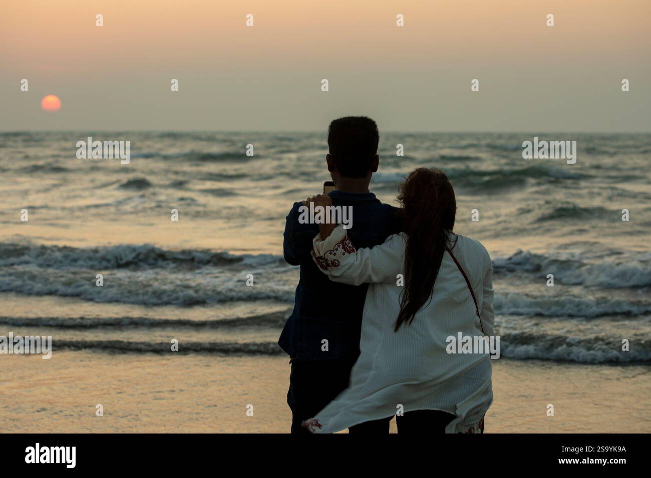 Un couple profitant de la vue sur le coucher du soleil depuis la plage de Saint Martin's Island, la seule île corallienne au Bangladesh, située dans la baie du Bengale au sein du Co Banque D'Images